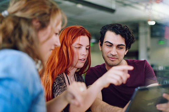 Unposed group of creative business people in an open concept office brainstorming their next project.-2