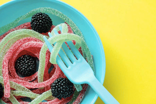 A single-use plastic fork and a plastic bowl filled with lollies