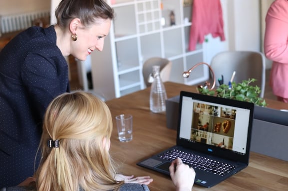 Two women working together on a laptop to write a strong product concept.